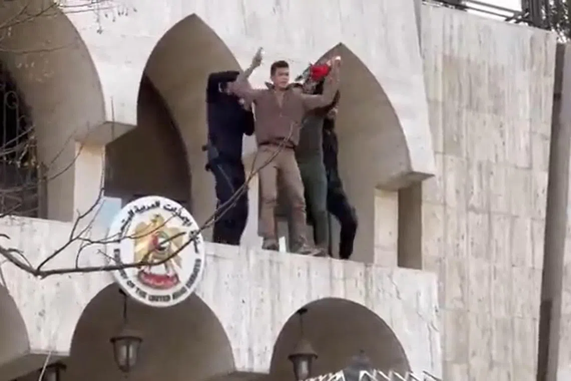 A screengrab from a video posted online that is said to show protesters removing the UAE flag from its embassy in Damascus.