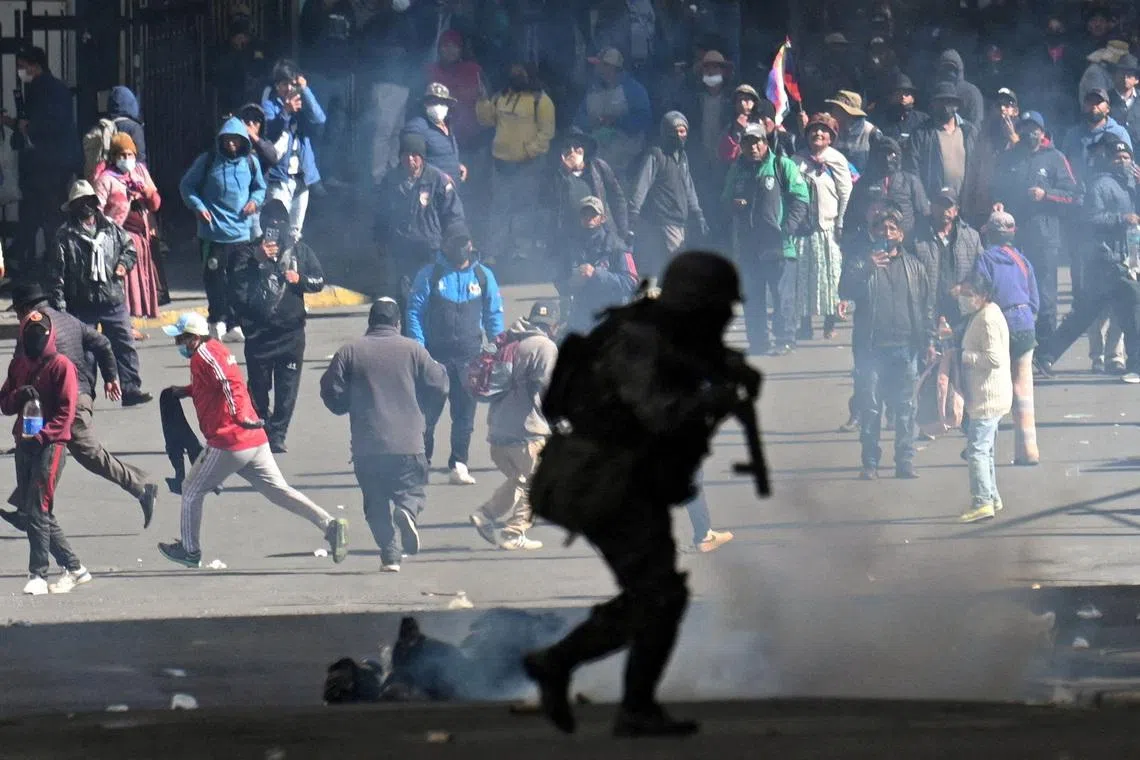 FILE PHOTO: A police officer runs in front of demonstrators during a march calling for the resignation of Bolivian President Rodrigo Paz, as the country’s economic and fuel crisis worsens due to a shortage of U.S. dollars and declining domestic energy production, in La Paz, Bolivia, May 25, 2026. REUTERS/Claudia Morales/ File Photo