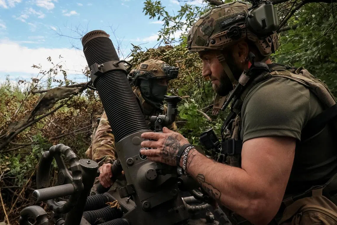 Ukrainian servicemen prepare to fire a mortar, near the city of Bakhmut in Ukraine's Donetsk region.