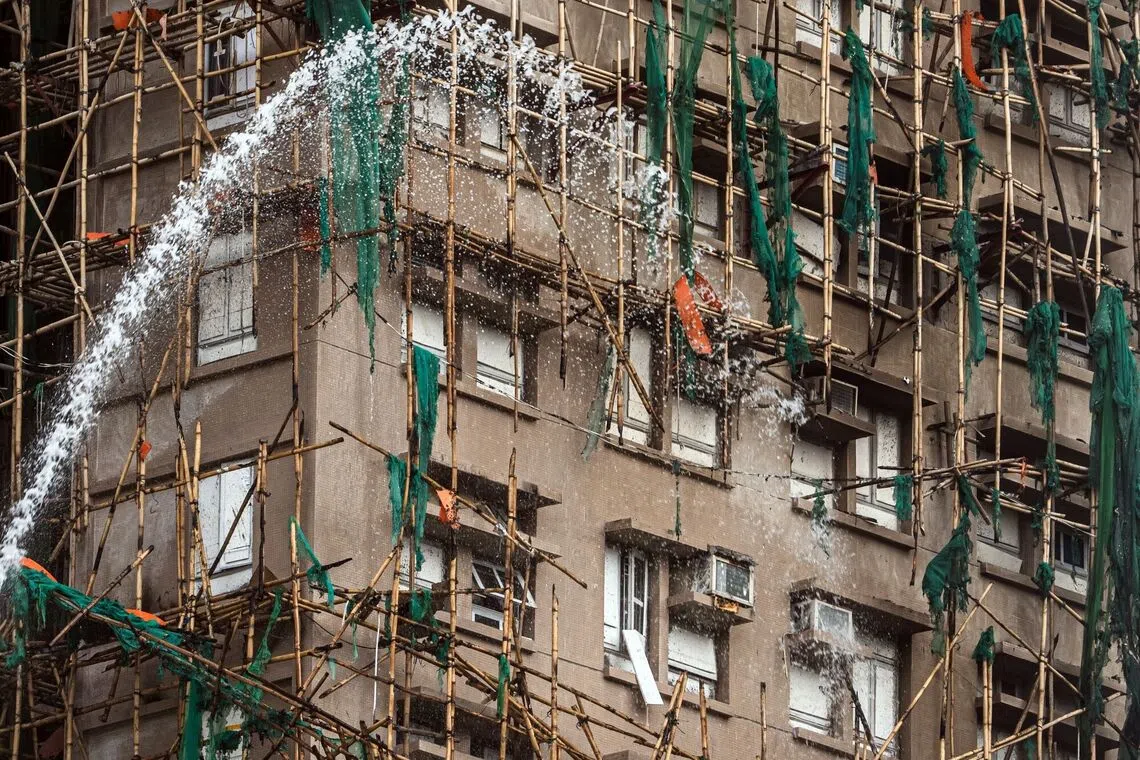 Firefighters hose down a smouldering residential building at the Wang Fuk Court in the Tai Po district of Hong Kong, China, on Thursday, Nov. 27, 2025. Hong Kong's worst residential fire in more than half a century has killed at least 44 people and left hundreds missing, throwing fresh scrutiny on the city's housing standards as Chinese President Xi Jinpingurges all-out efforts to reduce casualties. Photographer: Lam Yik/Bloomberg