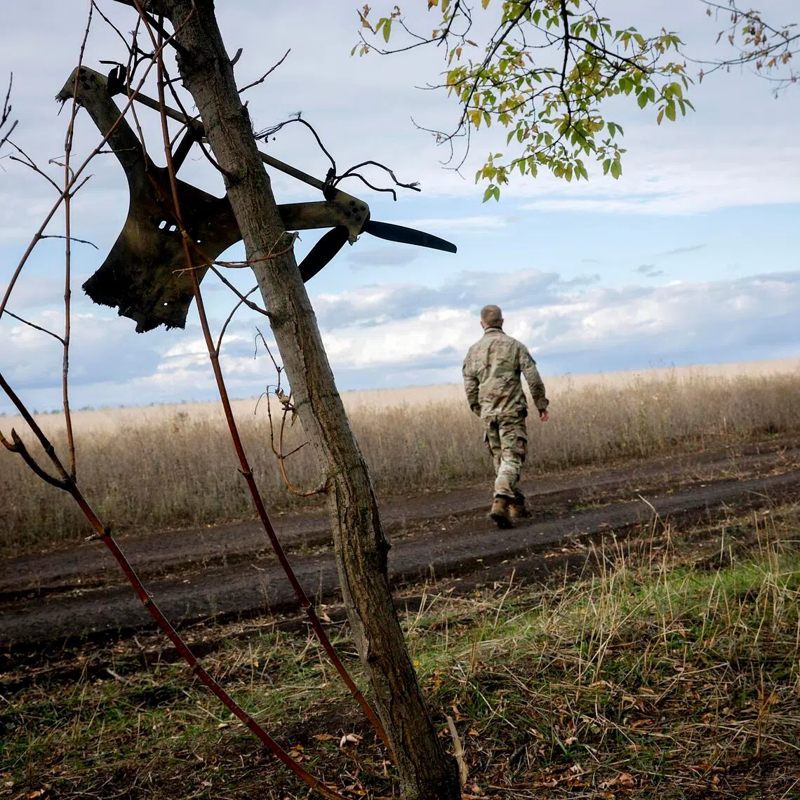 Ukrainian soldiers passing the remains of a Russian drone in the Zaporizhzhia region of Ukraine, in October 2025.