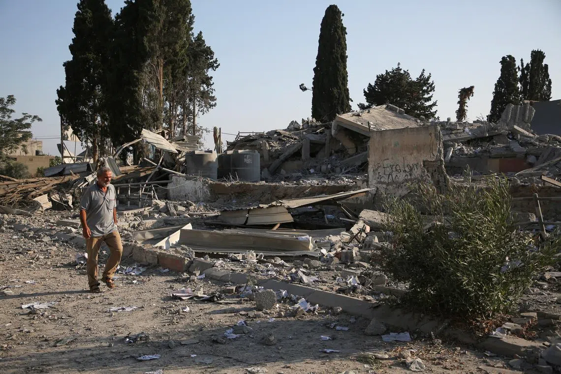 A Palestinian man walks near rubble, following an Israeli strike on a school sheltering displaced people, amid the Israel-Hamas conflict, in Khan Younis, in the southern Gaza Strip, June 27, 2024. REUTERS/Hatem Khaled