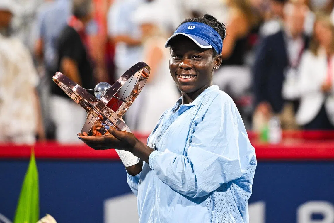 Aug 7, 2025; Montreal, QC, Canada; Victoria Mboko (CAN) tournament winner against Naomi Osaka (JPN) holds her trophy at IGA Stadium. Mandatory Credit: David Kirouac-Imagn Images