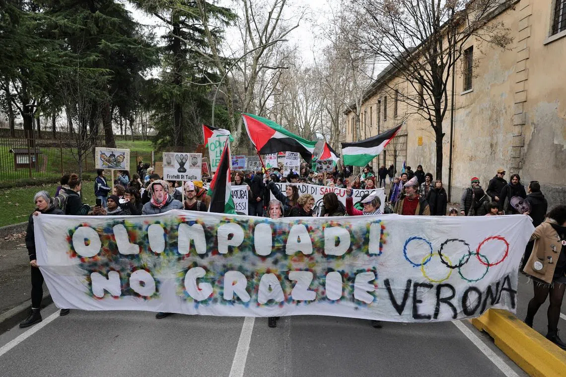 Protesters hold a banner reading "Olympics - No Thanks" on the day of the Winter Olympics closing ceremony.