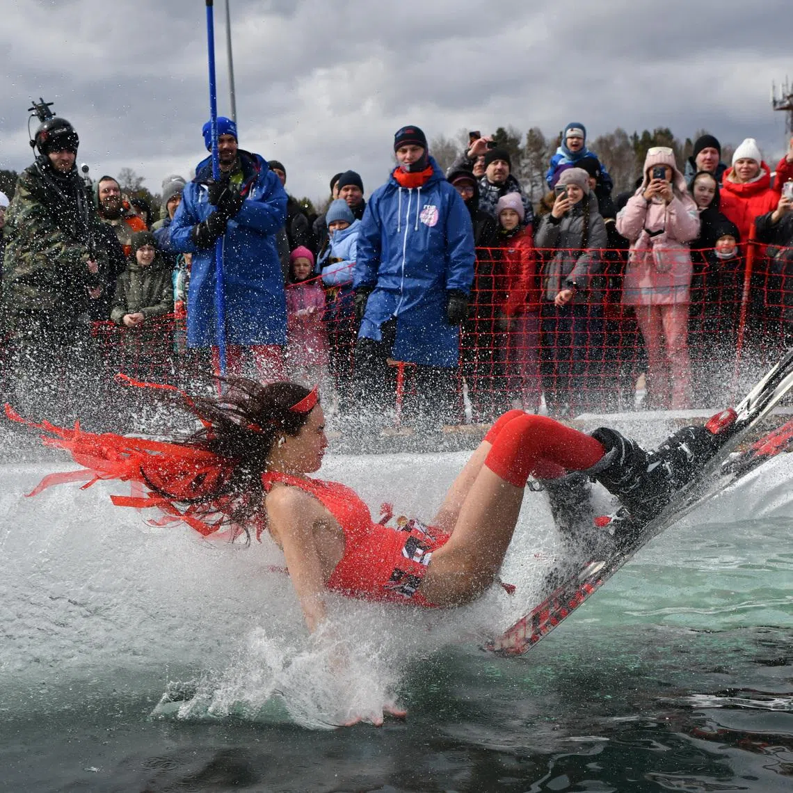 A skier in a festive costume attempting to cross a pool of water at the foot of a slope while competing in the annual Gornoluzhnik amateur event marking the end of a ski season at the Bobrovy Log fun park in Krasnoyarsk, Russia, April 19.