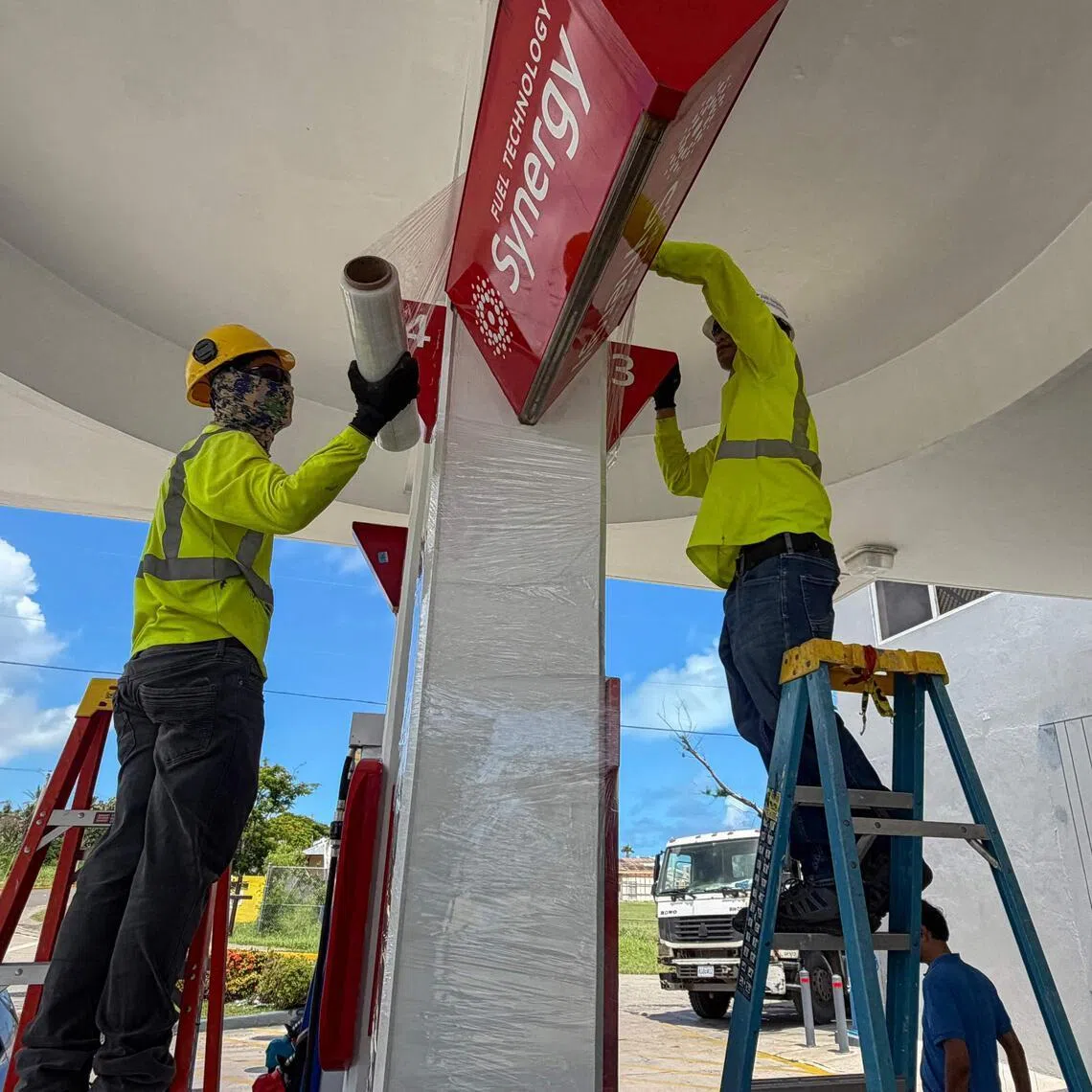 Workers secure a gas station ahead of the arrival of the forecasted Super Typhoon Bavi in Saipan, Northern Mariana Islands, on July 3.