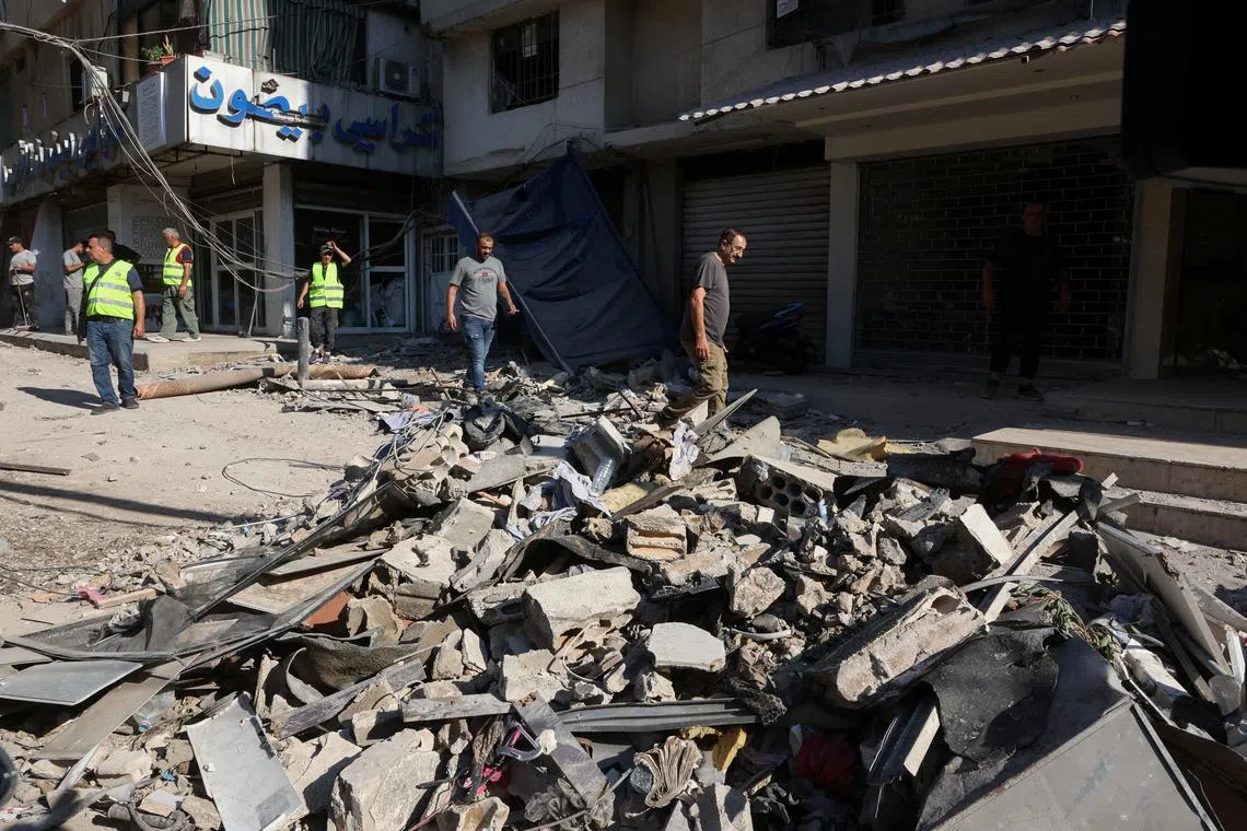 People walk on the rubble of a damaged site the day after an Israeli strike, in Beirut's southern suburbs, Lebanon July 31, 2024. REUTERS/Mohamed Azakir