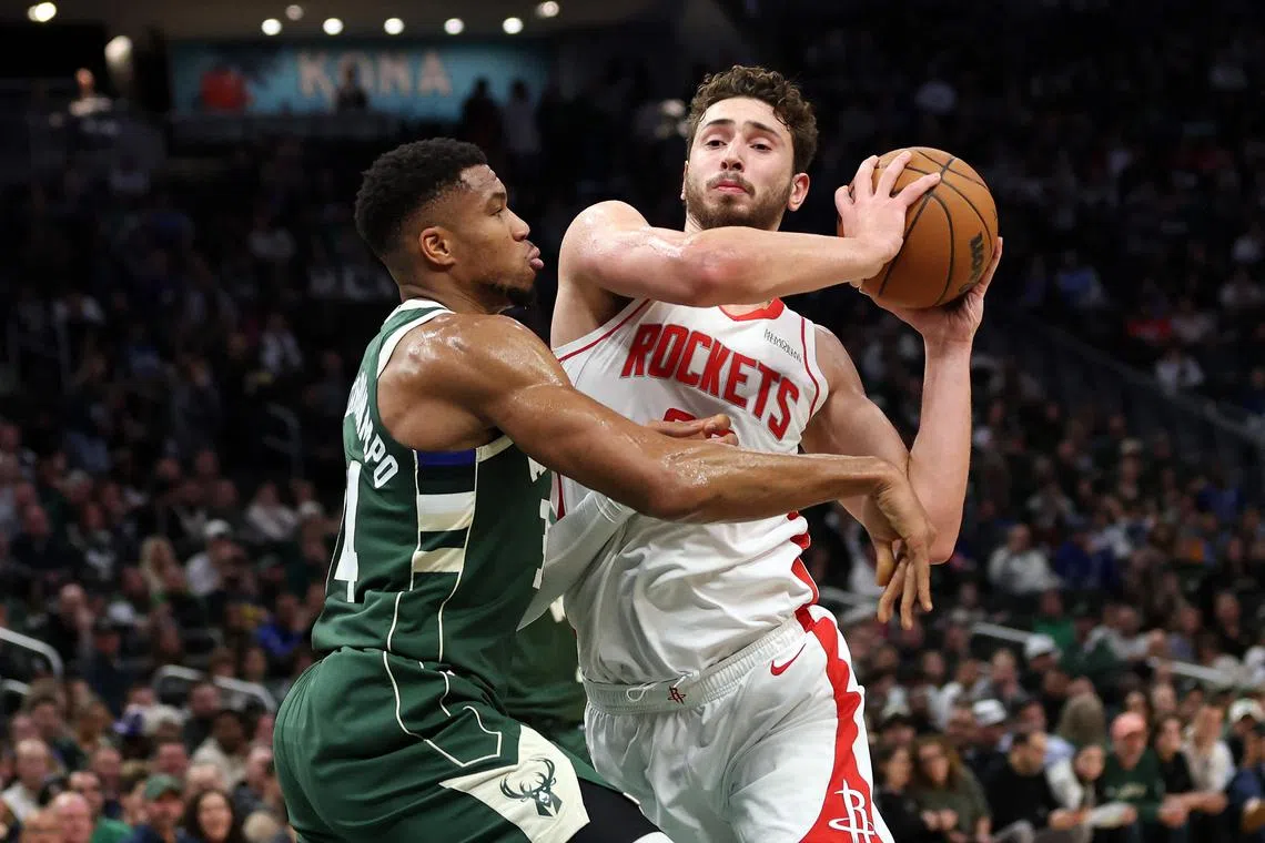 Alperen Sengun of the Houston Rockets is defended by Giannis Antetokounmpo of the Milwaukee Bucks during a game at Fiserv Forum.