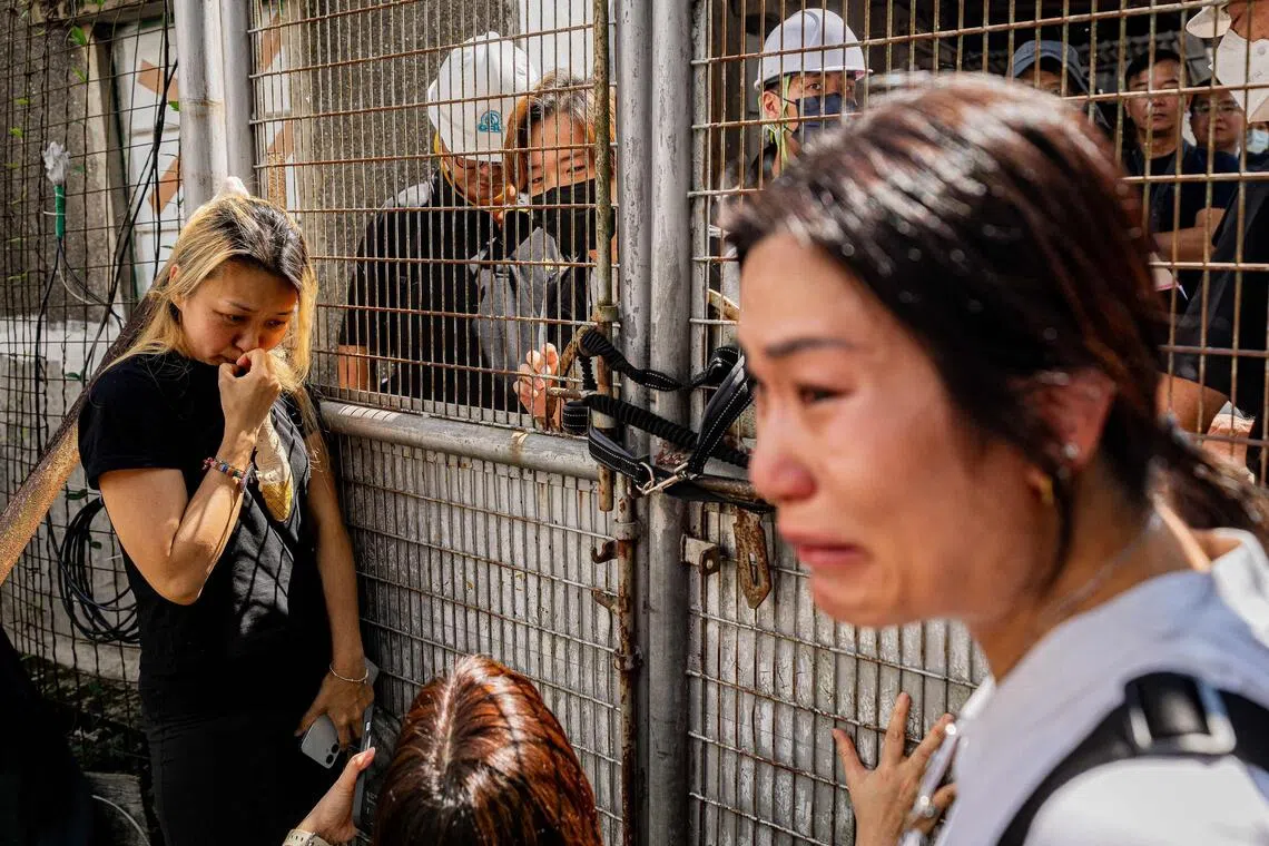 Resident Niki So (left) and her family stand behind the gate of their village house as Hong Kong government officers carry out a land resumption operation against them in the Kwu Tung area of Hong Kong’s northern New Territories.