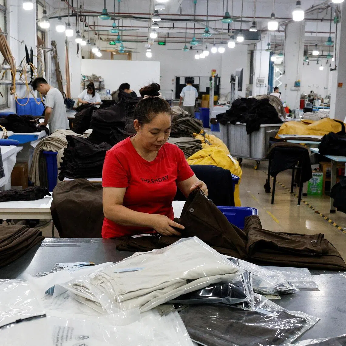 Employees work on a production line at a garment factory in Panyu District, Guangzhou, Guangdong province, China, July 27, 2026. REUTERS/Go Nakamura