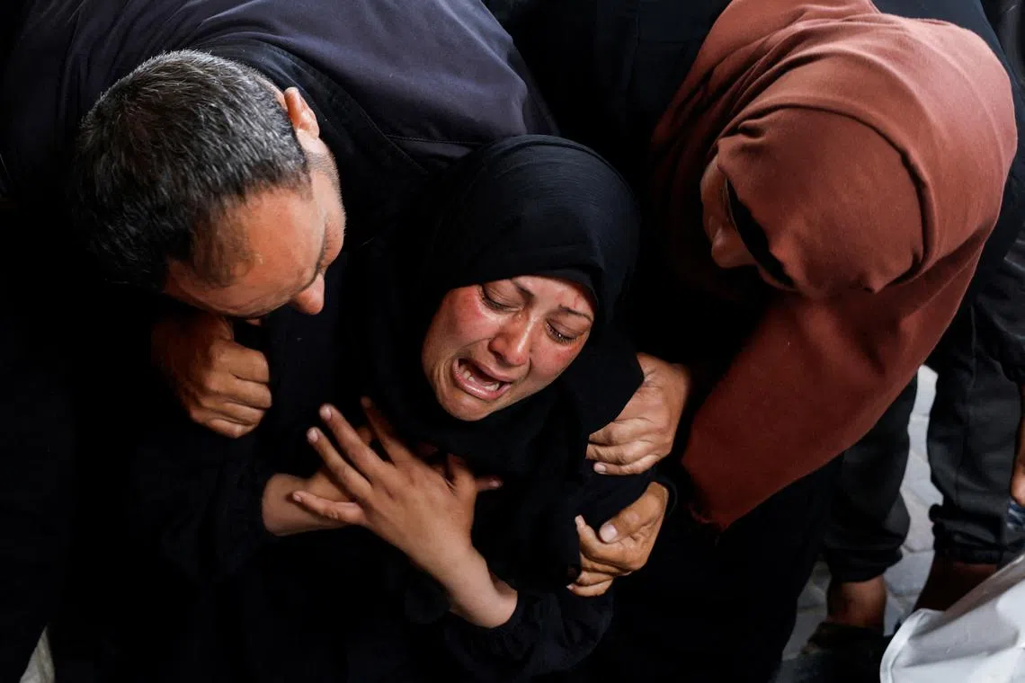 A woman reacts next to the bodies of Palestinians killed in Israeli strikes, amid the ongoing conflict between Israel and Hamas, in Rafah, in the southern Gaza Strip, on April 16, 2024.