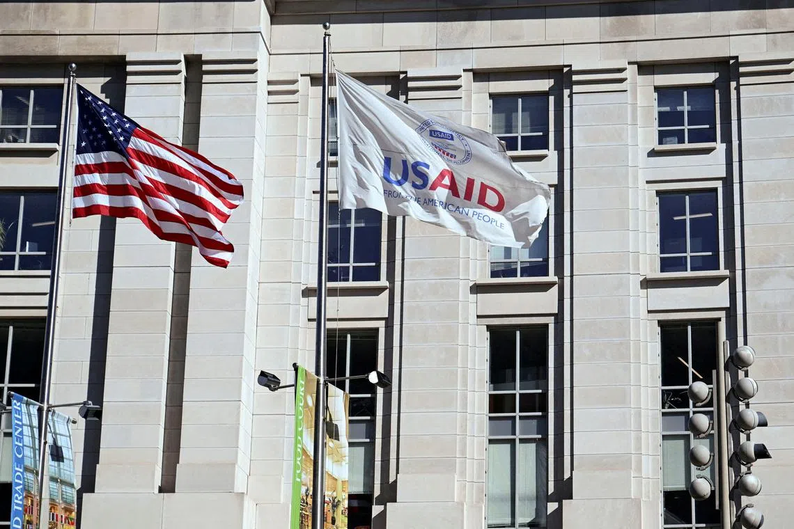 FILE PHOTO: An American flag and USAID flag fly outside the USAID building in Washington, D.C., U.S., February 1, 2025. REUTERS/Annabelle Gordon/File Photo