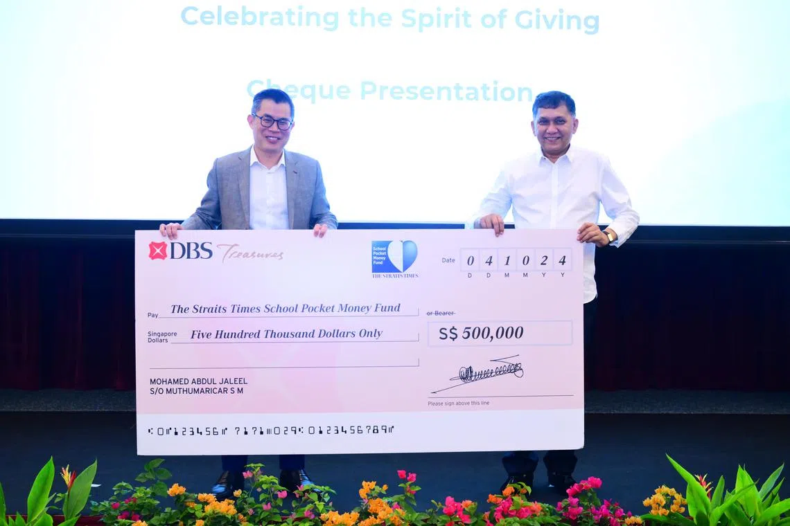 MES Group founder and chief executive Mohamed Abdul Jaleel Muthumaricar S M (right) presents a cheque to ST editor Jaime Ho at the appreciation lunch on Oct 4.