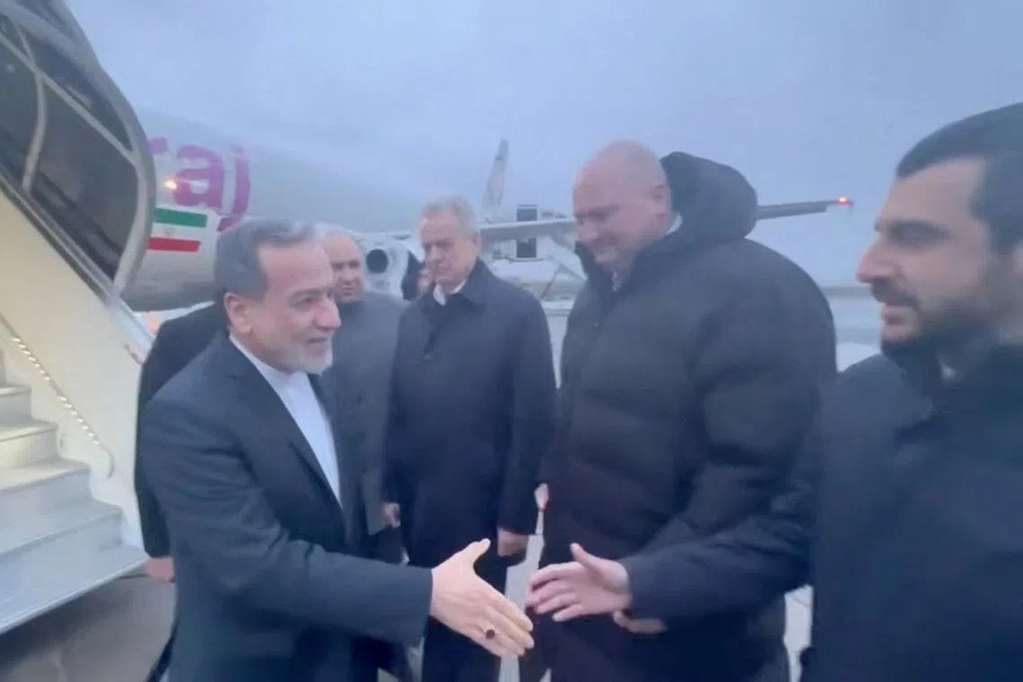 Iran's Foreign Affairs Minister Abbas Araqchi (left) is greeted by officials during his visit to Russia for talks with Russian President Vladimir Putin, in a place given as St. Petersburg on April 27.