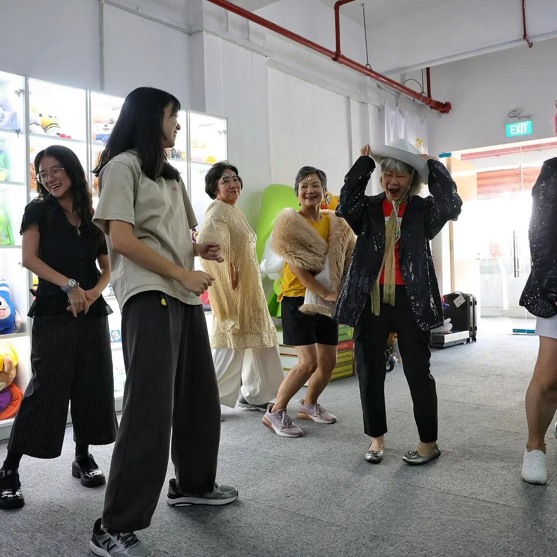 Kerin Chua (far left) and Trishea Goh (second from left), both students from Lasalle College of the Arts, teaching seniors some K-Pop dance moves at the Sing, Shine, Share event on Aug 29.