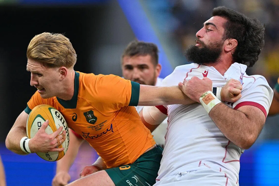 Australia's Tate McDermott is tackled by Georgia's Vladimer Chachanidze during the rugby union Test match at Allianz Stadium in Sydney on July 20, 2024.