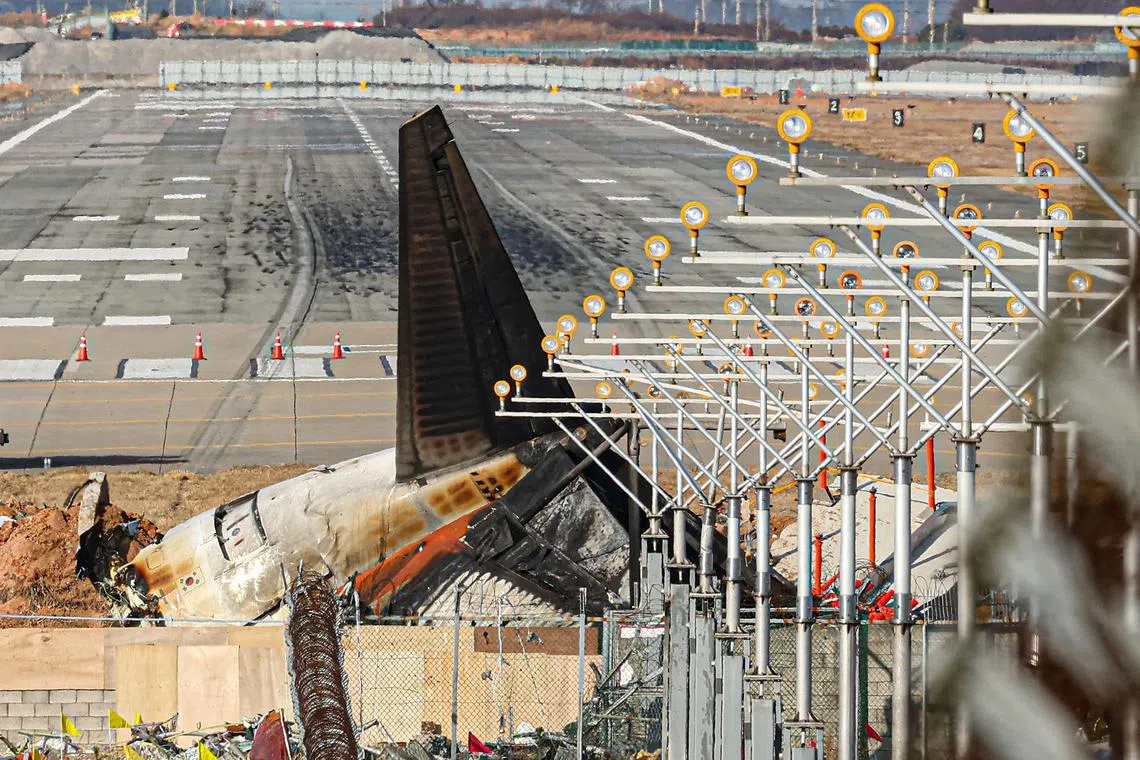 The wrecked tail section of the Jeju Air Boeing 737-800 aircraft that crashed and burst into flames on Dec 29 is seen at the end of the runway at Muan International Airport in Muan on Dec 30. 