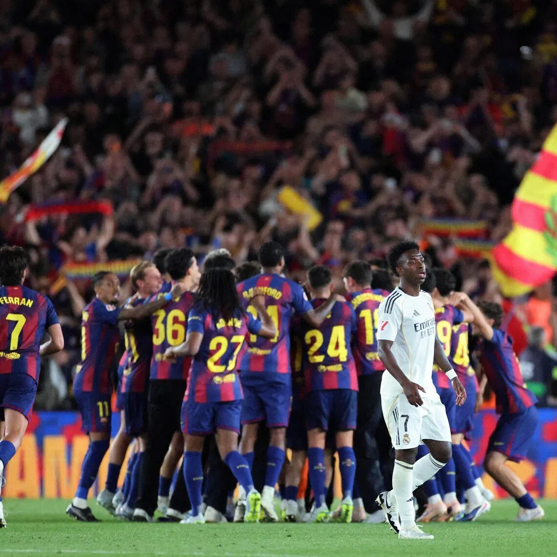 Real Madrid’s Vinicius Junior looking dejected as FC Barcelona players celebrate winning the LaLiga in May 2026.