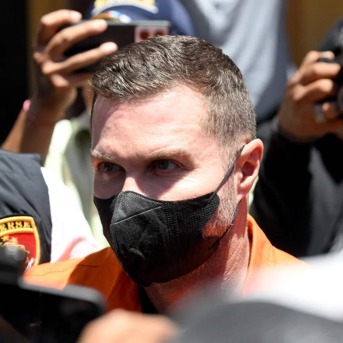 Scottish national Steven Lyons being escorted by police officers at the Bali police headquarters in Denpasar, on March 31.