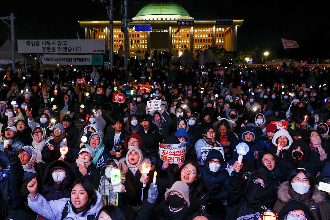 Protesters react after South Korean President Yoon Suk Yeol, who declared martial law which was reversed hours later, survived an impeachment motion, in front of the National Assembly in Seoul, South Korea, Dec 7, 2024.