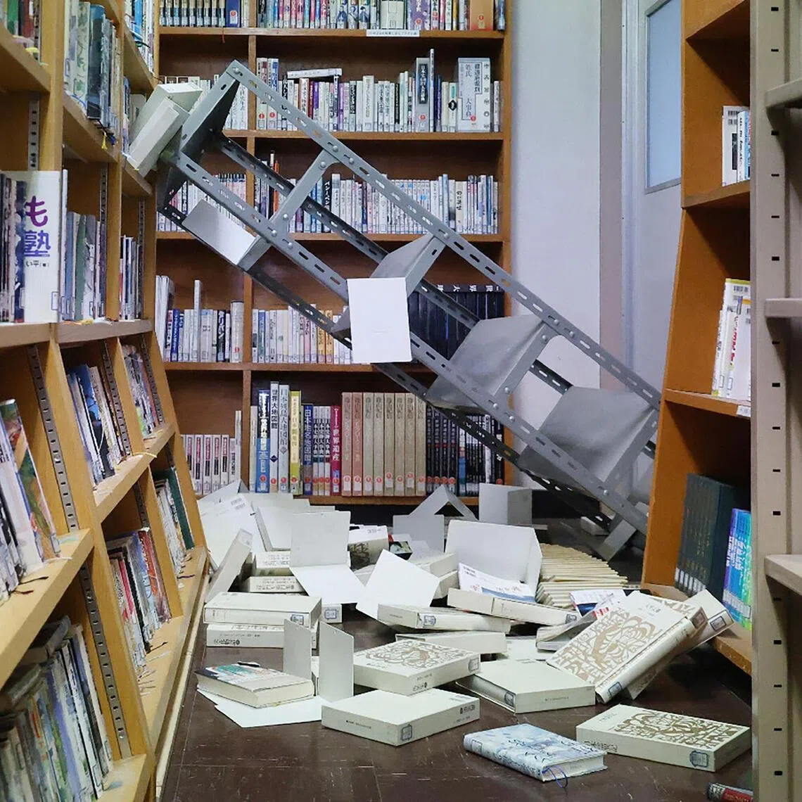 Collapsed bookshelves at a high school library is seen in Hachinohe City in Aomori Prefecture on Dec 9, 2025, following a 7.5-magnitude earthquake off northern Japan.