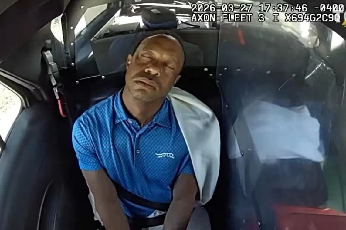 A video screengrab showing Tiger Woods in the back of a police car after crashing his SUV and undergoing a sobriety test.