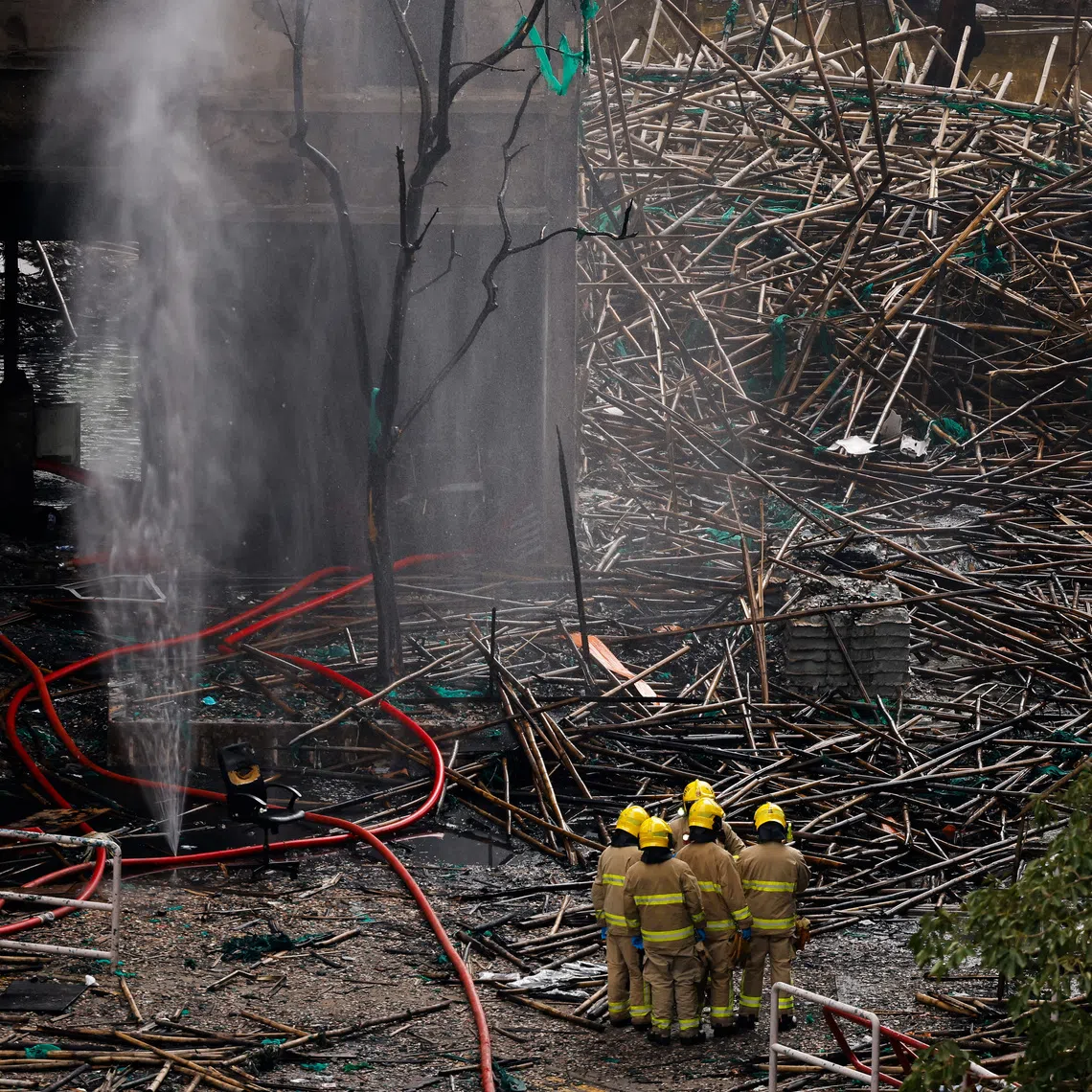 Firefighters gather next to bamboo scaffolding debris at the Wang Fuk Court housing complex after the deadly fire, in Tai Po, Hong Kong, China, December 1, 2025. REUTERS/Maxim Shemetov