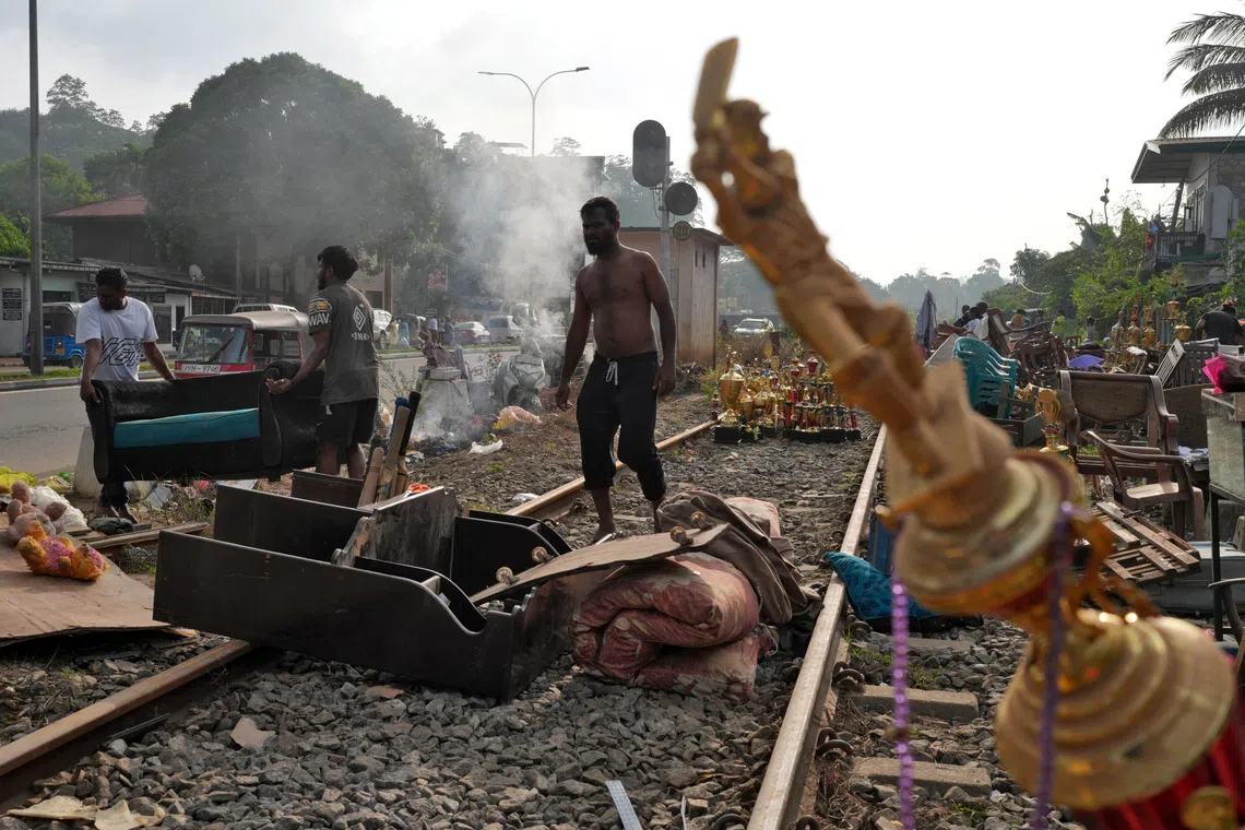 People affected by floods collect their belongings from the railway tracks after drying them following Cyclone Ditwah Kandy, Sri Lanka, December 3, 2025. REUTERS/Thilina Kaluthotage