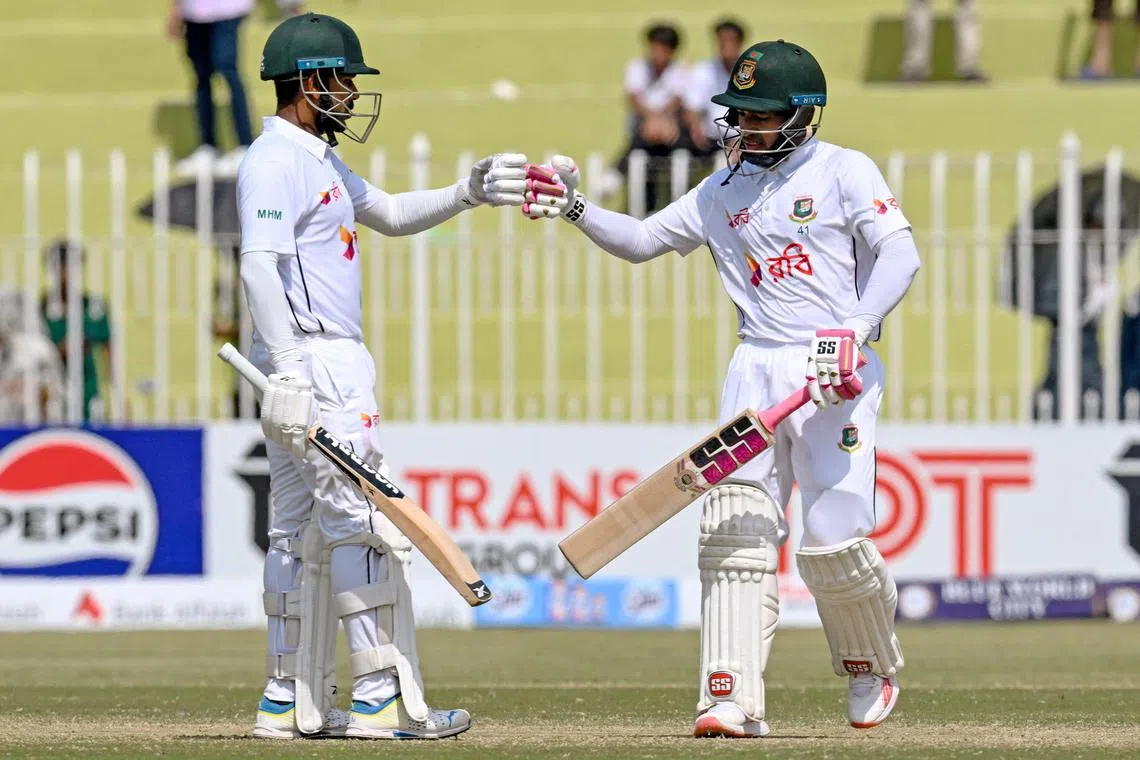 Bangladesh's Mushfiqur Rahim (right) and Mehidy Hasan Miraz bump fists on the fourth day of the first Test against Pakistan at the Rawalpindi Cricket Stadium on Aug 24, 2024.
