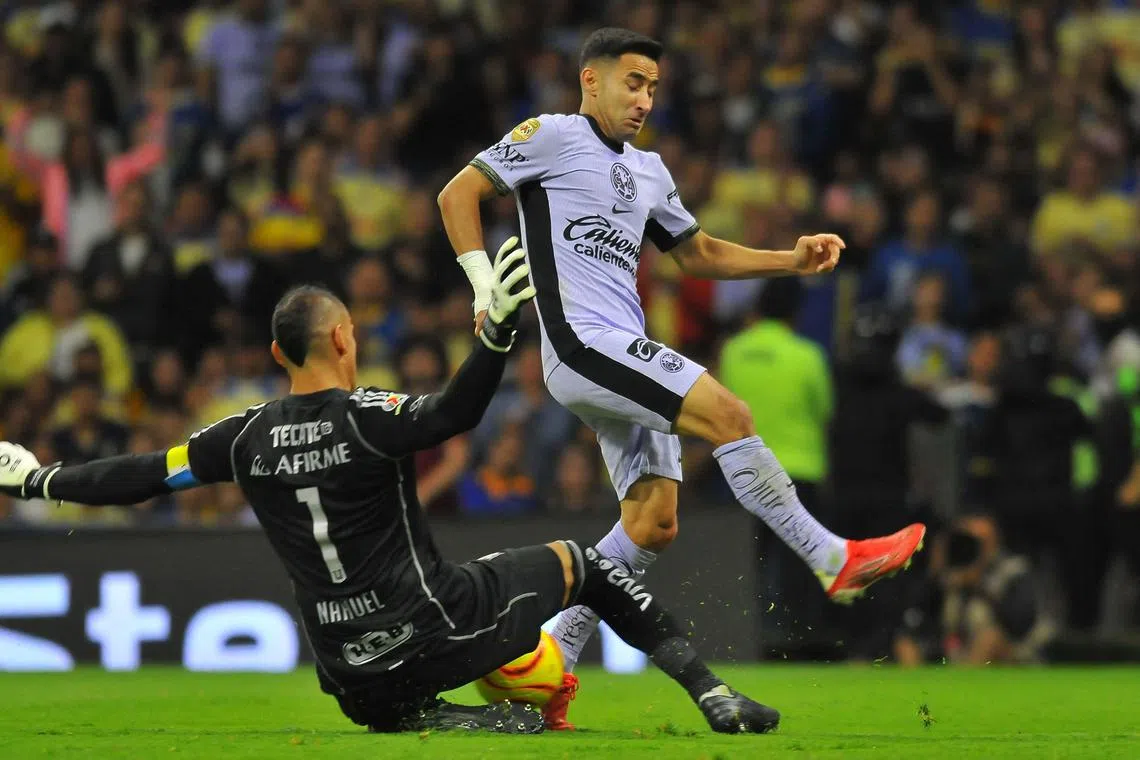 Tigres goalkeeper Nahuel Guzman fighting for the ball with America's Luis Fuentes in their Mexican Clausura match at the Azteca stadium in Mexico City on March 9, 2024.
