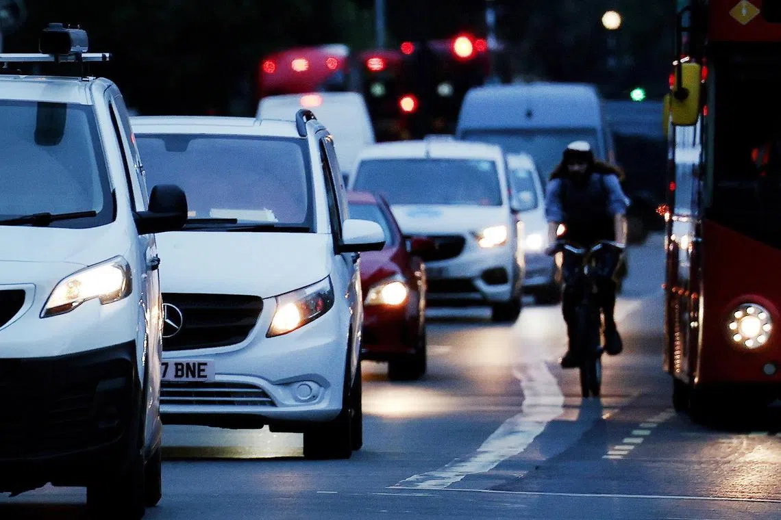 epa10871425 A cyclist rides along with the early morning traffic in London, Britain, 20 September 2023. The UK Government is expected to announce Net Zero commitment delays. British Prime Minister Rishi Sunak is expected to set out plans for watered down targets on cars and boilers during a Net Zero speech at Downing Street, on 20 September.  EPA-EFE/ANDY RAIN