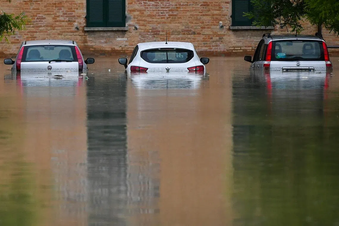 Flooded cars are pictured in a street of Cesena, Italy, on May 17, 2023.