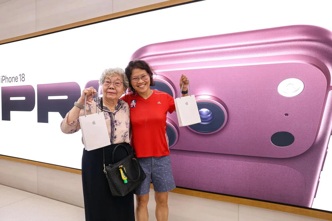 Chin Chu (left) and her daughter Irene holding their new iPhone 18 Pro phones during the launch on Sept 18.