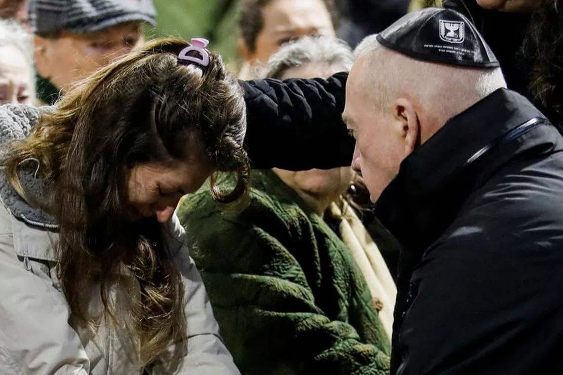 Israeli Defence Minister Yoav Gallant comforts the wife of Israeli military commander Lieutenant Colonel Tomer Grinberg, who was killed in northern Gaza amid the Israeli army's ongoing ground operation in the Gaza Strip, during Grinberg's funeral at Mount Herzl military cemetery in Jerusalem, December 13, 2023. REUTERS/Shir Torem/File Photo