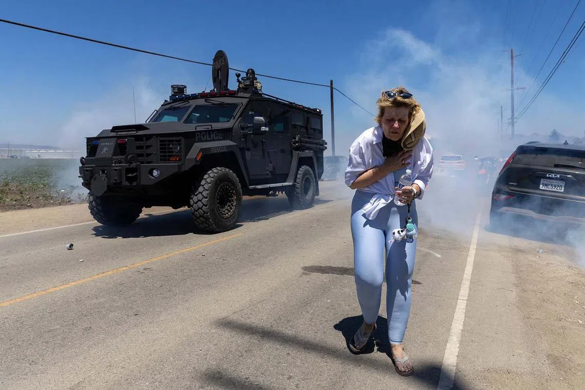 A protestor fleeing as Customs and Border Protection officers fire chemical agents into the crowd during a raid by Federal Immigration Agents at Glass House Farms in Camarillo, California, July 10, 2025. The raid targeted state licensed cannabis and other crop operations, detaining between a dozen and 100 farmworkers, and deploying smoke or tear gas canisters and rubber bullets to disperse a crowd of several hundred protesters on Laguna Road. 
