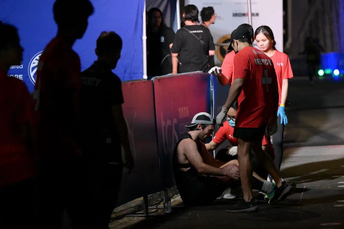 Medics helping a half-marathoner after he crosses the finishing line at Stanchart Singapore Marathon on Dec 1.