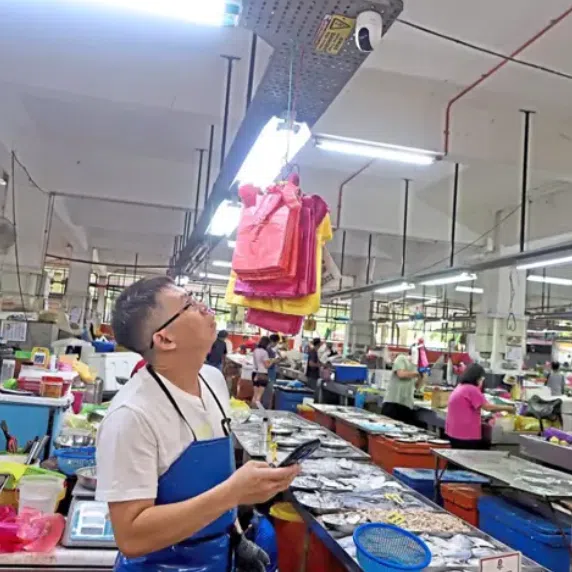 A fishmonger looking at the CCTV he installed at his stall at the Batu Lanchang market in George Town, Penang. 