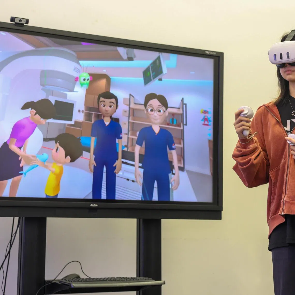 NYP School of Design and Media student Alyssa Tan, demonstrating her final year project, a virtual reality simulation that helps help young cancer patients prepare for radiotherapy treatment, on April 28, 2026.