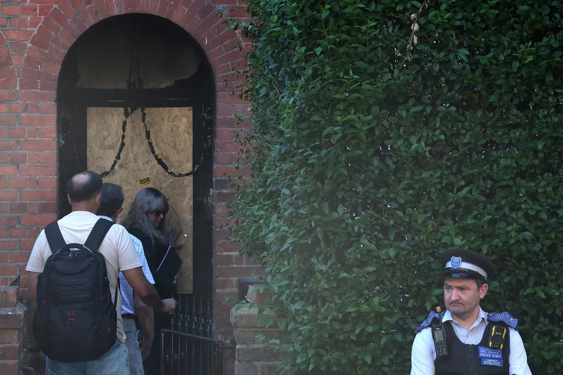 A police officer stands on duty whilst people enter Britain's Prime Minister Keir Starmer's private home, after it was damaged by fire in a suspected arson attack in north London, Britain, May 13, 2025. REUTERS/Toby Melville