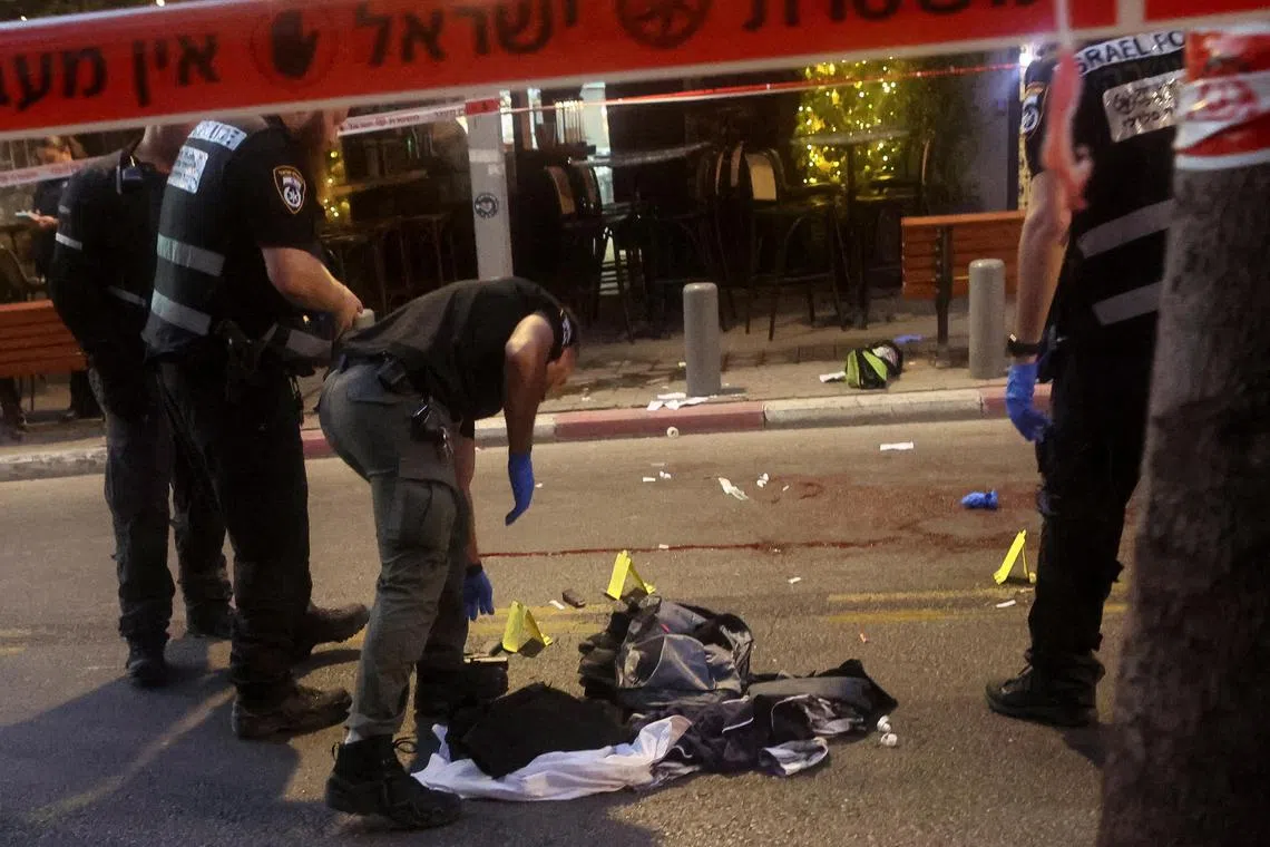 Israeli police inspect the scene of the attack, on a street in central Tel Aviv.
