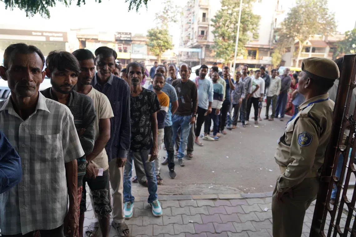 epa10349444 Indian voters stand in a line to cast their votes at a polling station in Ahmadabad, Gujarat, India, 05 December 2022. Polling for the second and final phase of Gujarat assembly elections begins with 833 candidates in the fray for 93 seats. The results will be announced on 08 December 2022.  EPA-EFE/SIDDHARAJ SOLANKI