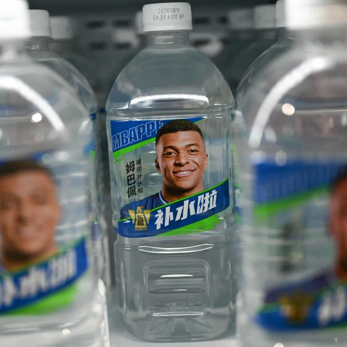 Bottles of Dongpeng Beverage Group’s Bushuila electrolyte drink featuring French football star Kylian Mbappe on the packaging.