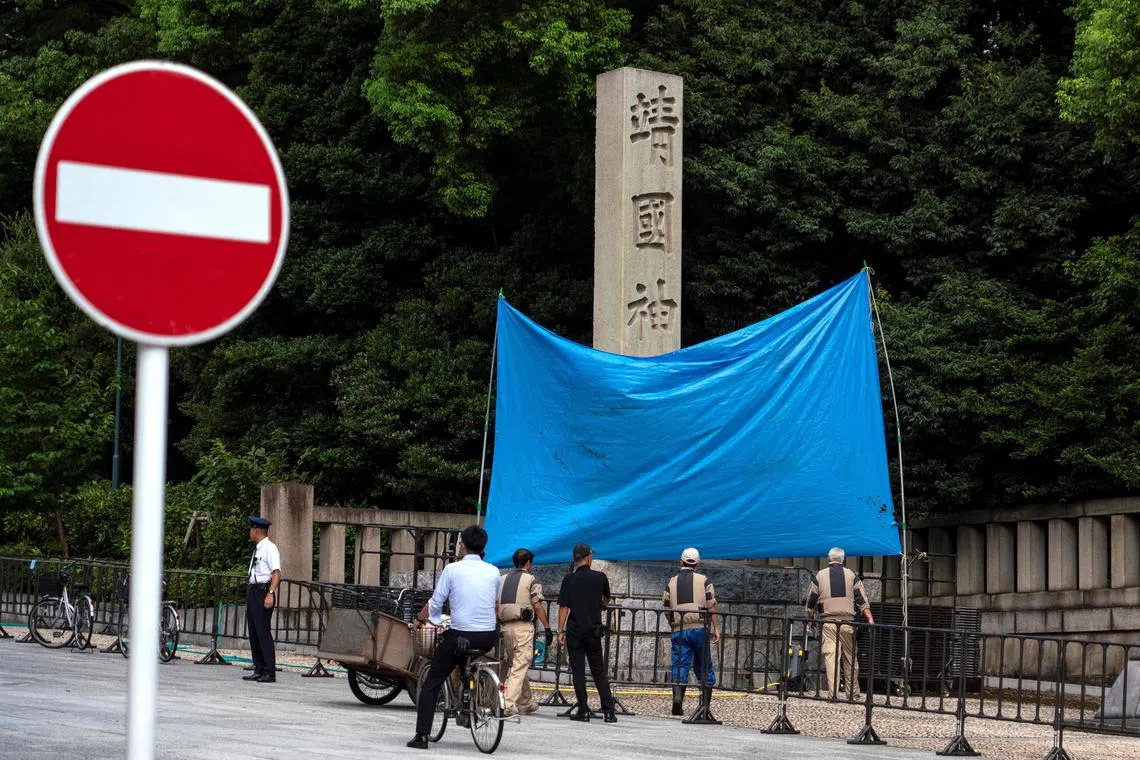 A blue sheet obscures the stone pillar which bears the name of the Yasukuni Shrine, after graffiti was found on the structure.