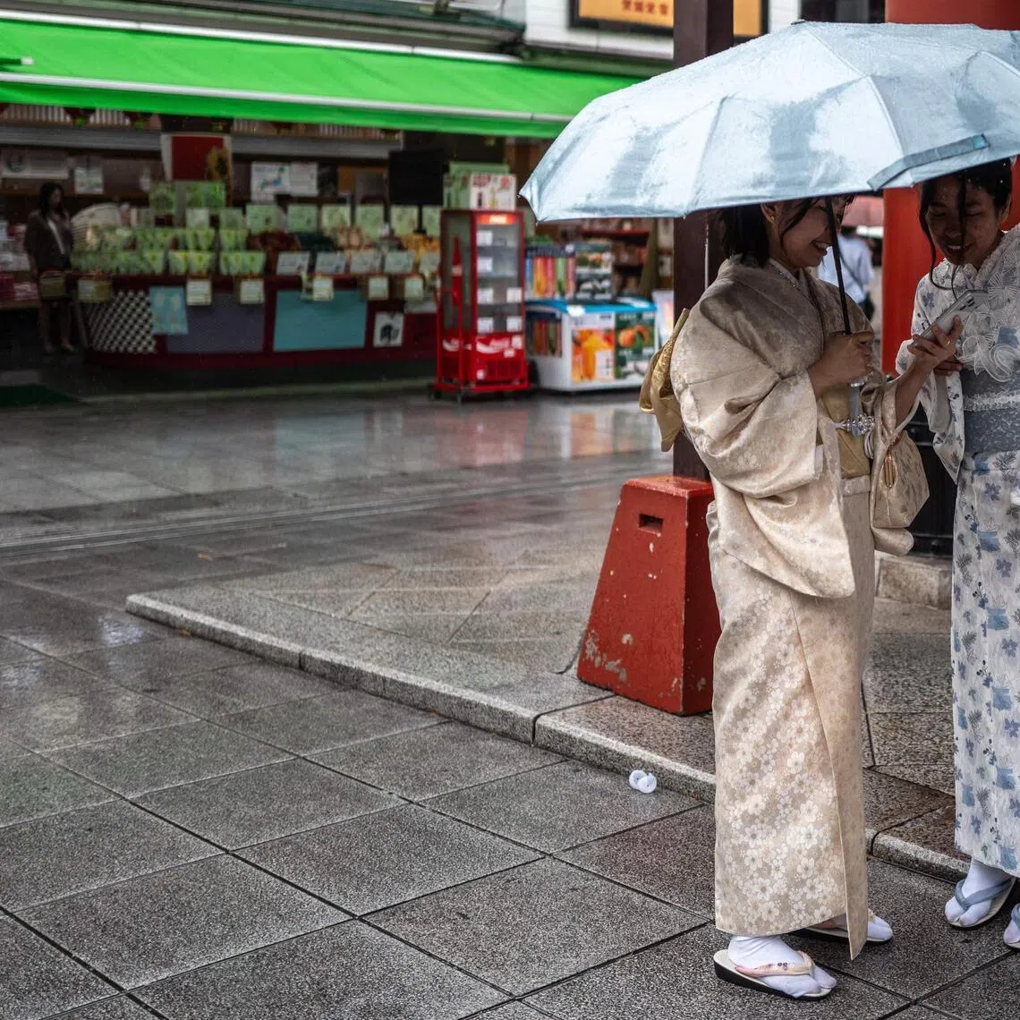People talk at the shopping street of Sensoji Temple, a popular tourist location, in Tokyo’s Asakusa district on June 25.