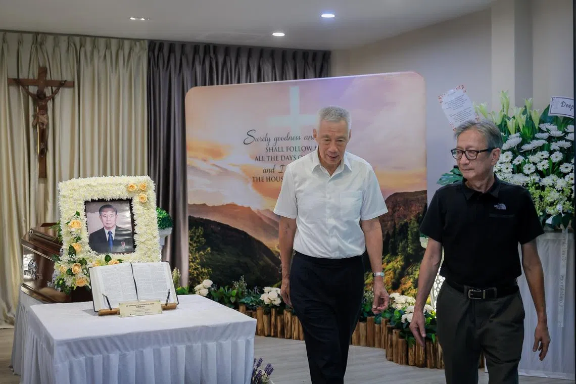 Senior Minister Lee Hsien Loong paying his respects at the wake of former Toa Payoh MP Eric Cheong at the Chapel of the Resurrection, St Joseph’s Church. With them is Cheong’s eldest son, Peter (black top).