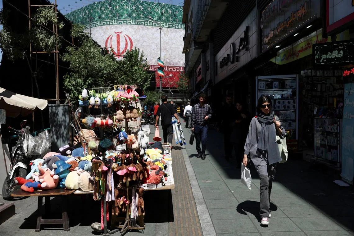 An Iranian woman walks on a street, after U.S. and Iranian officials said they had reached a deal to end their war and reopen the Strait of Hormuz, in Tehran, Iran, June 15, 2026. Majid Asgaripour/WANA (West Asia News Agency) via REUTERS