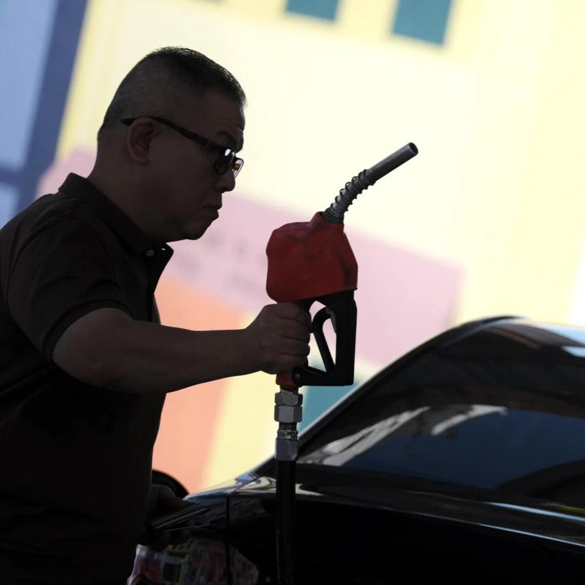 A man pumps his car with petrol at Cnergy petrol station along Dunman Road on March 17, 2026.