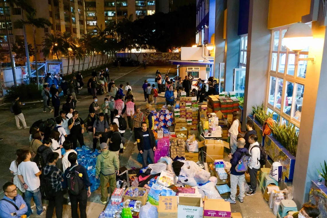 Essential supplies are piled outside a temporary shelter near the Wang Fuk Court residential estate in Hong Kong on Nov 26.