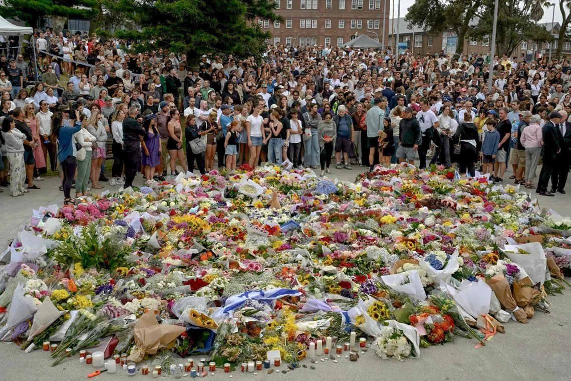 Mourners gather by floral tributes at the Bondi Pavillion in memory of the victims of a shooting at Bondi Beach in Sydney. 