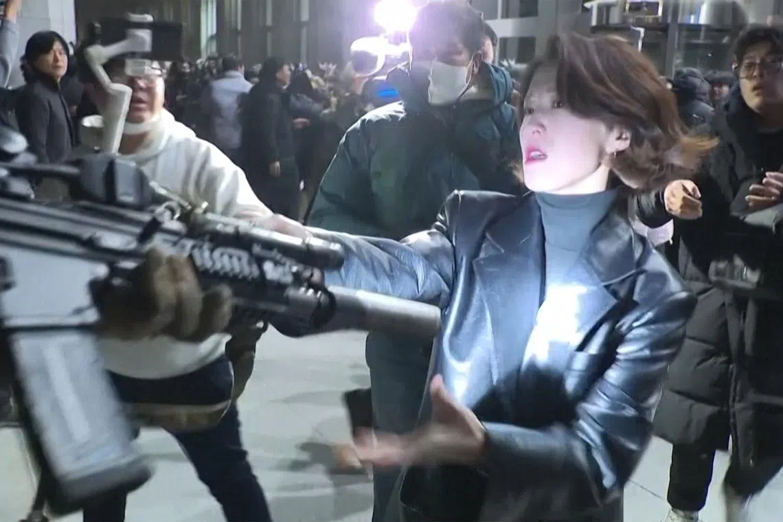 A video still of South Korean female politician, Ahn Gwi-Ryeong, holding rifle of martial law troop.